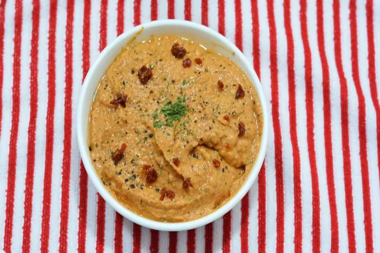 A photo of Traditional Maltese Arjoli Dip (tomato and garlic dip) topped with sun-dried tomatoes