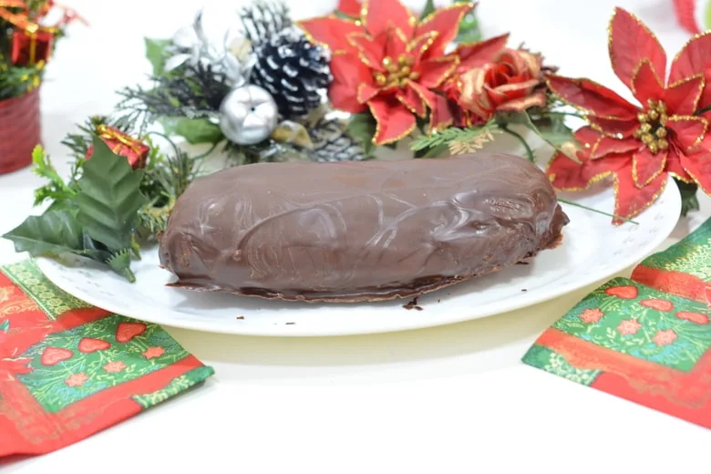 a whole Maltese Christmas log decorated with poinsettias and festive decorations