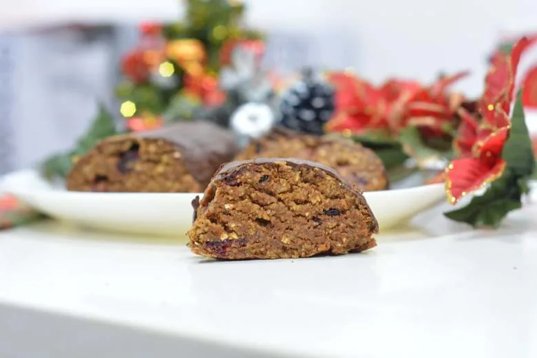 A slice of vegan Maltese Christmas Log decorated in colorful decorations