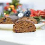 A slice of vegan Maltese Christmas Log decorated in colorful decorations