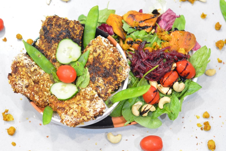 Top shot of crispy baked tofu served with colorful side salads